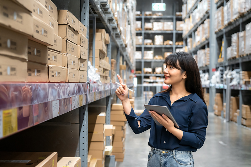 Cadrage sur une employée qui inventorie un entrepôt