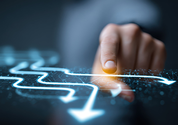 Une main trace un chemin numérique lumineux à côté d'une icône de recherche, symbolisant un accès rapide à des informations clés